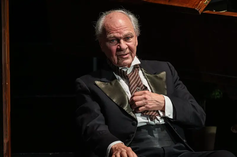 Actor adjusts formal jacket during Zemlinsky photo rehearsal, Theater in der Josefstadt Vienna