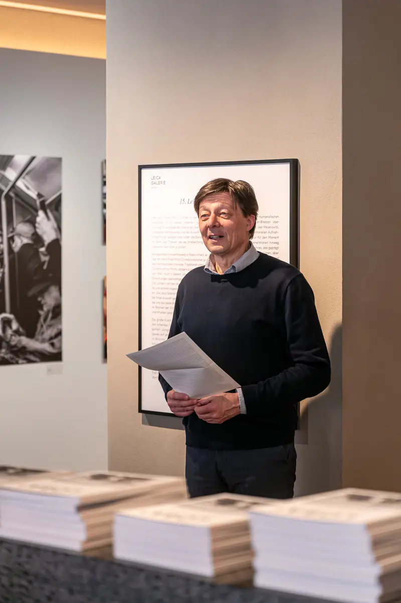 Attendee Reviewing Catalog at 15th Street Photo Contest, Leica Gallery Vienna