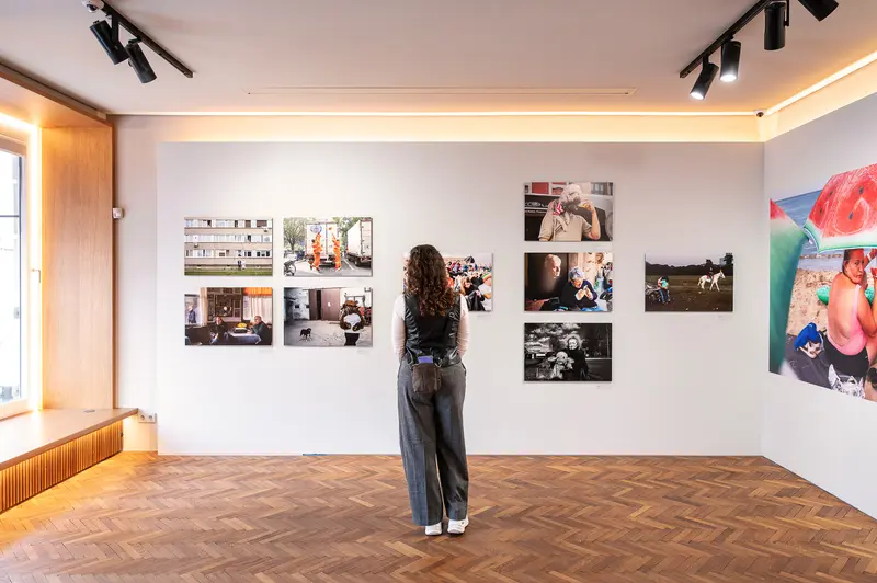 Visitor Examines Street Photography at 15th Street Photo Contest, Leica Gallery Vienna