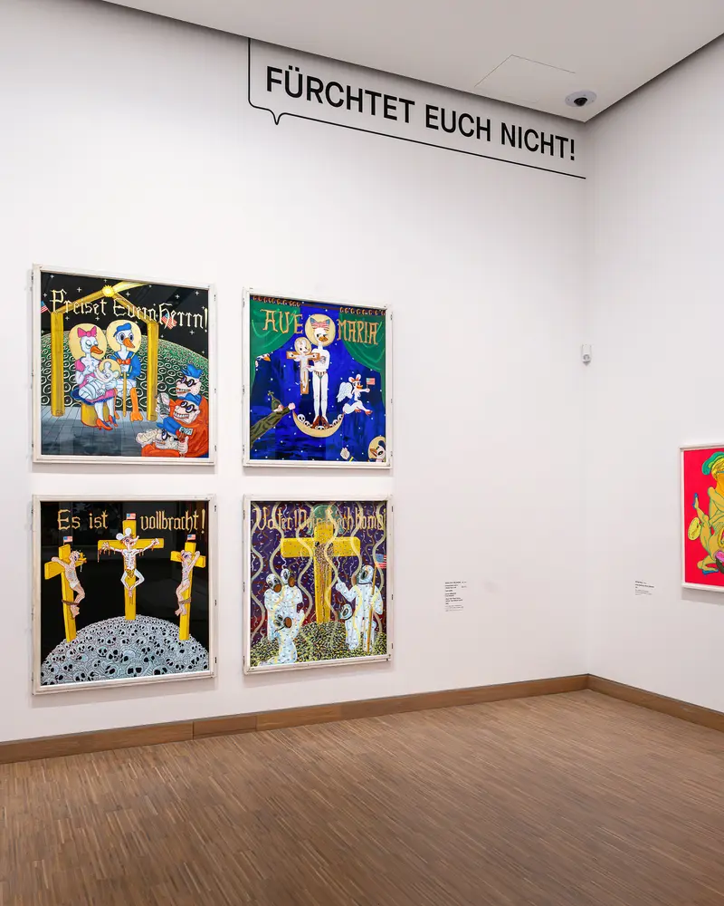 Gallery wall with four comic-inspired religious paintings under speech bubble banner
