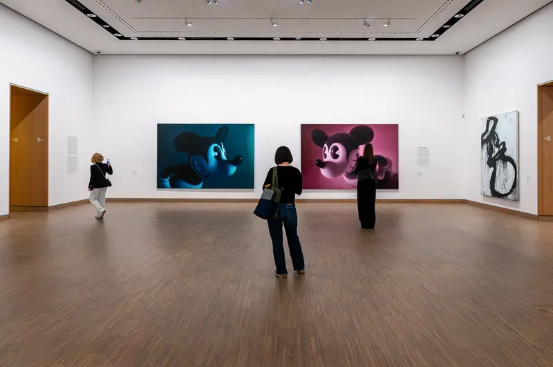 Gallery visitors viewing KAWS MICKEY MOUSE paintings at Albertina Modern Vienna