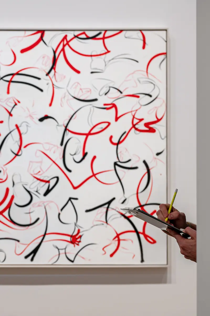 Visitor Viewing Abstract Painting with Red and Black Gestural Lines