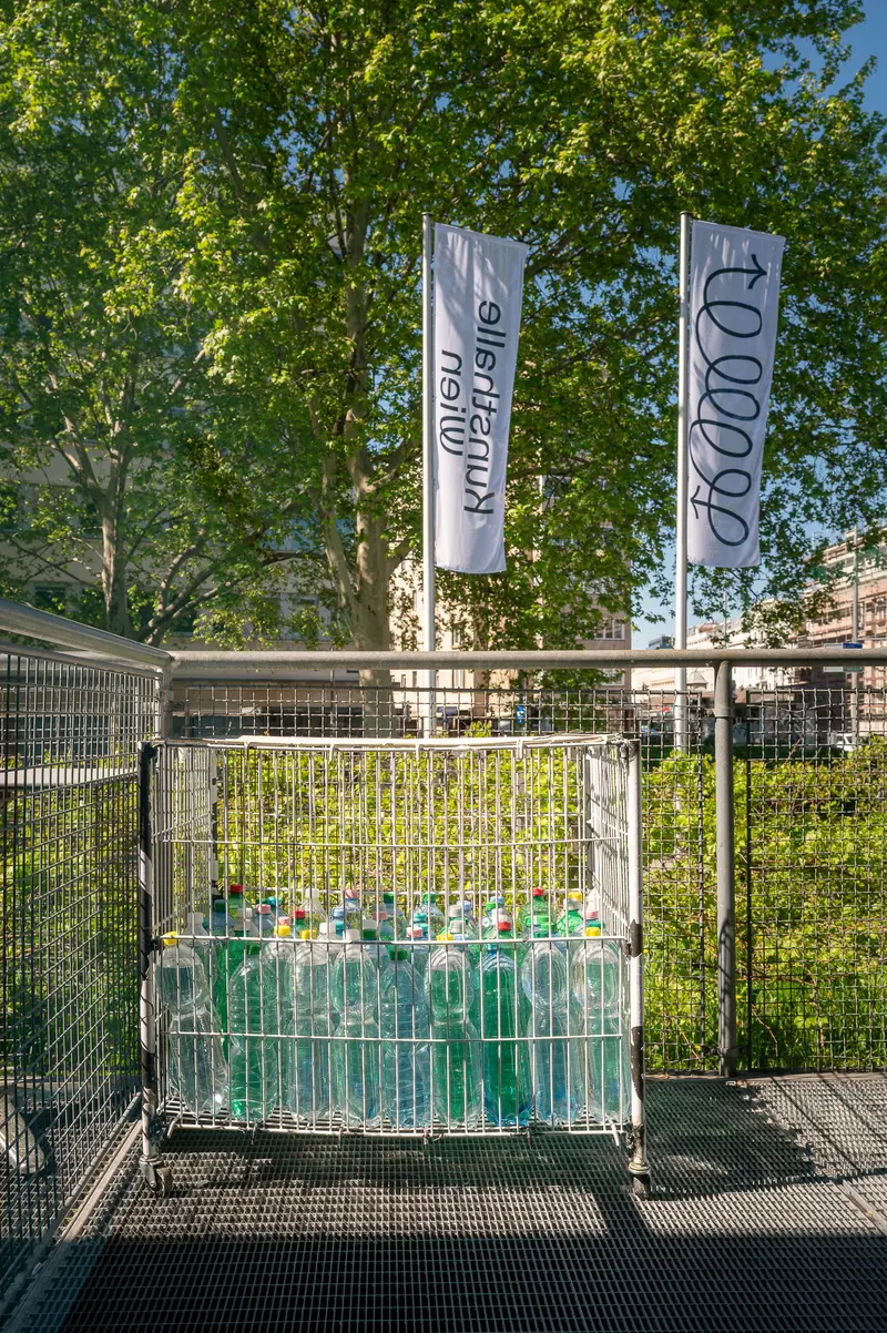 Green waste collection bin with promotional banners in urban park setting