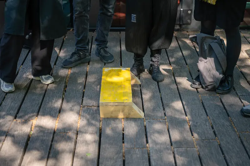Yellow Safety Equipment on Wooden Deck with Assembled Participants