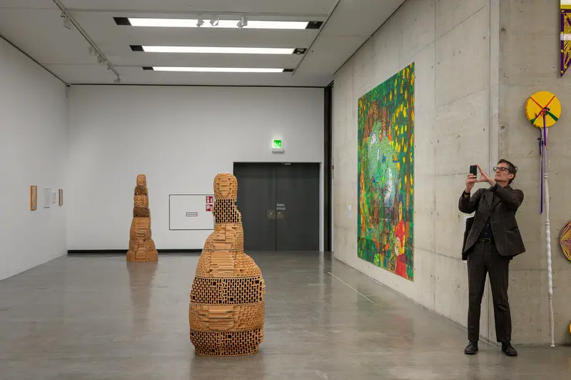 Visitor Photographing Contemporary Art Installation in Gallery Space