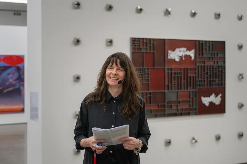 Woman Holding Exhibition Catalog in Contemporary Art Gallery