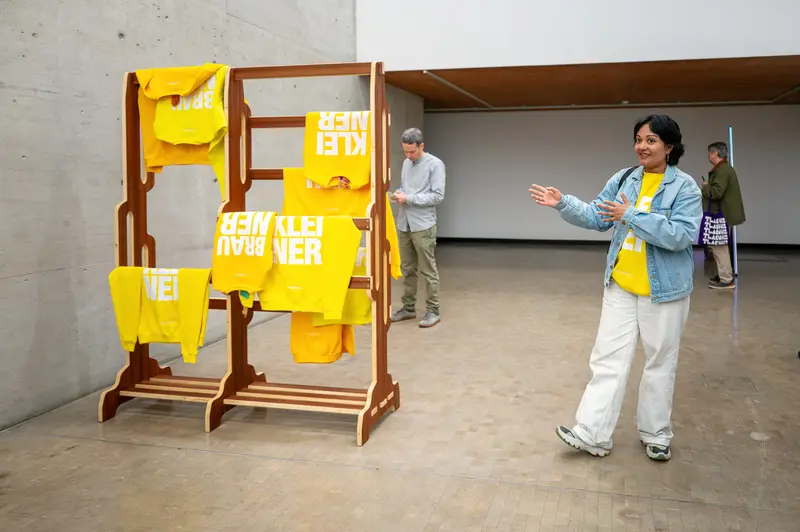 Artist Presenting Yellow Sculptural Installation in Contemporary Gallery Space