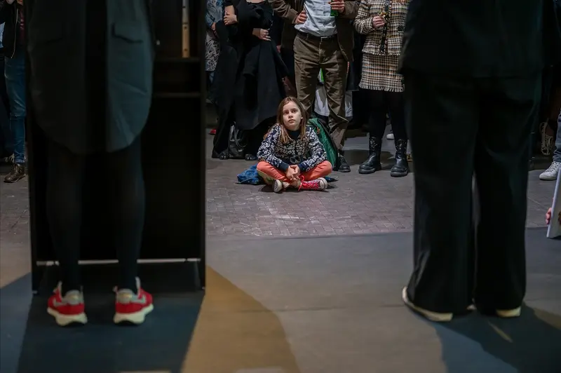 Young Girl Seated Among Visitors at Kunsthalle Wien Exhibition Opening