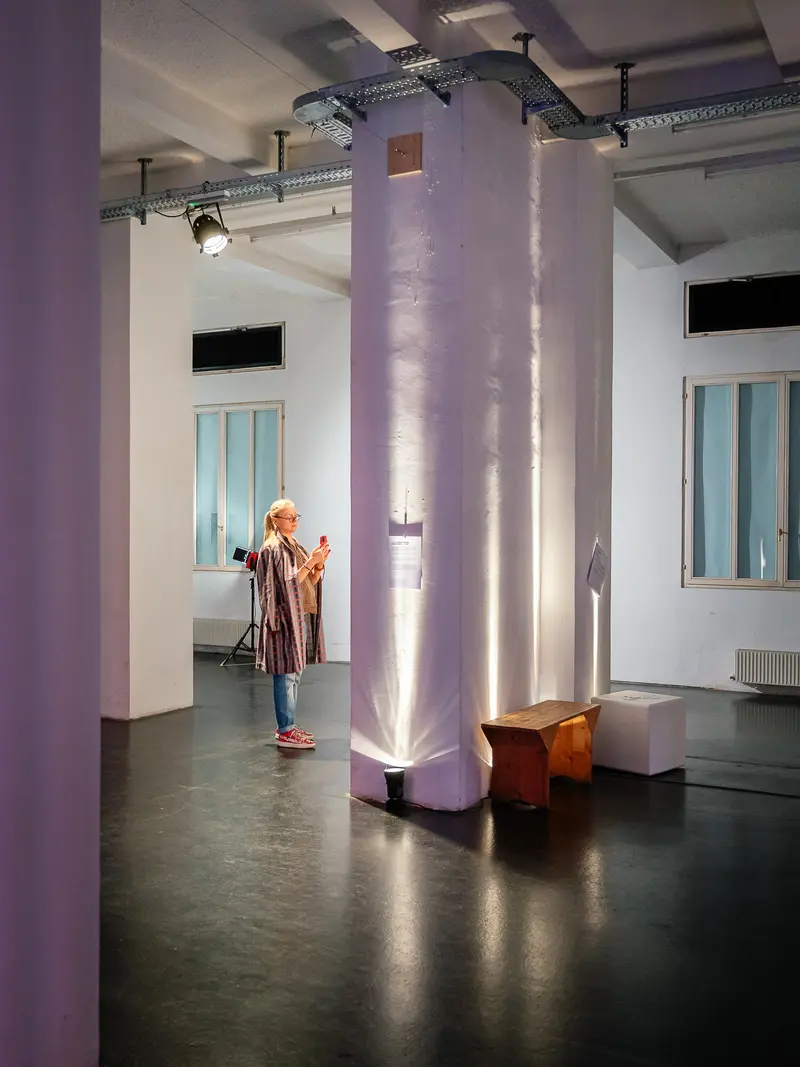 Performer in Purple-Lit Gallery Installation with Architectural Column