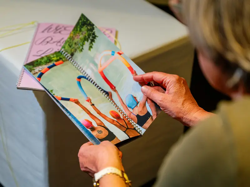 Woman Reviewing Colorful Artwork and Sketches at Table