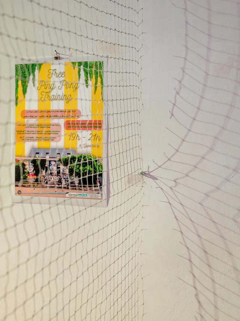 Promotional Poster Behind Safety Netting in White Gallery Space