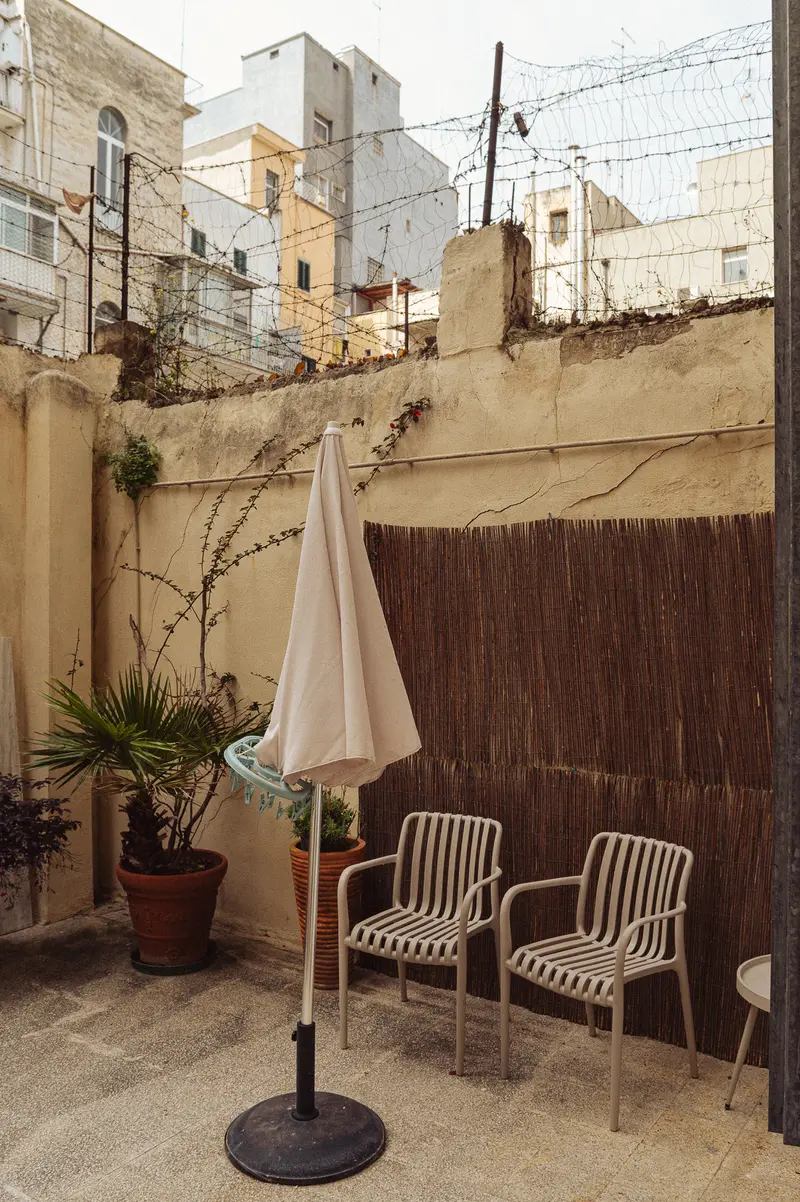 Rooftop Courtyard Seating Area with Striped Chairs and Umbrella