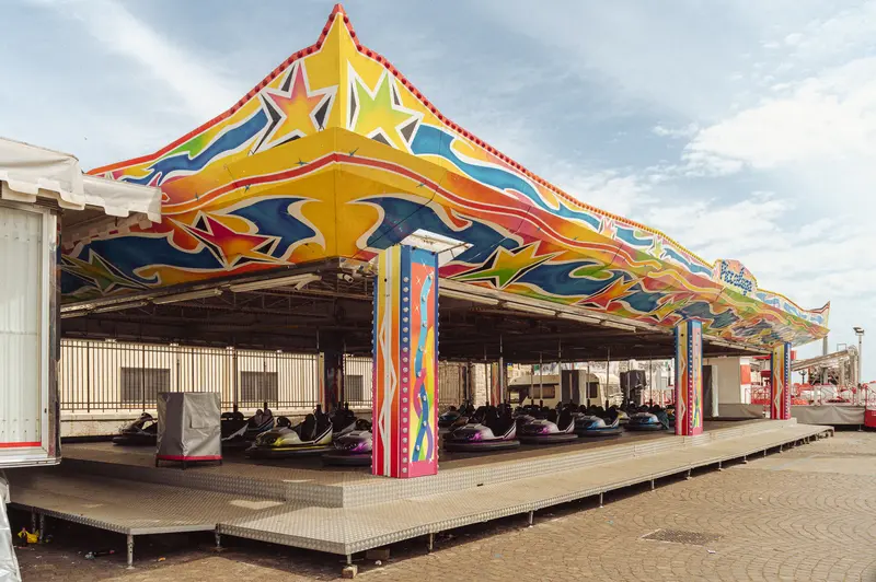 Colorful Fairground Ride Structure with Yellow Canopy and Red Support Pillars