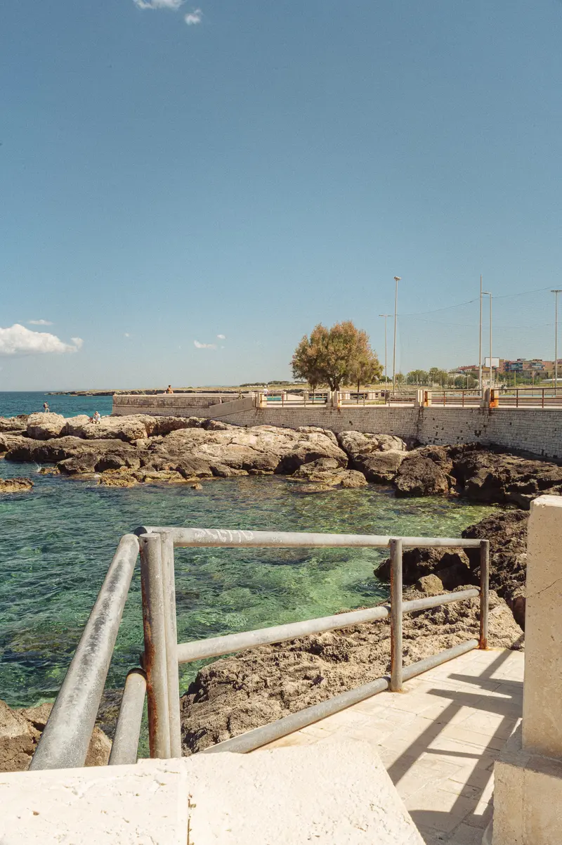 Coastal Waterfront Promenade with Rocky Shoreline and Marina
