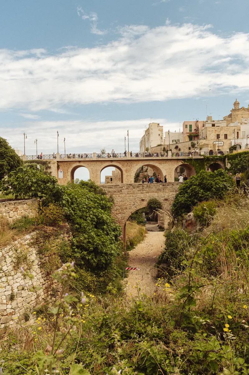 Ancient Stone Bridge with Arched Spans Over Ravine in Mediterranean Town
