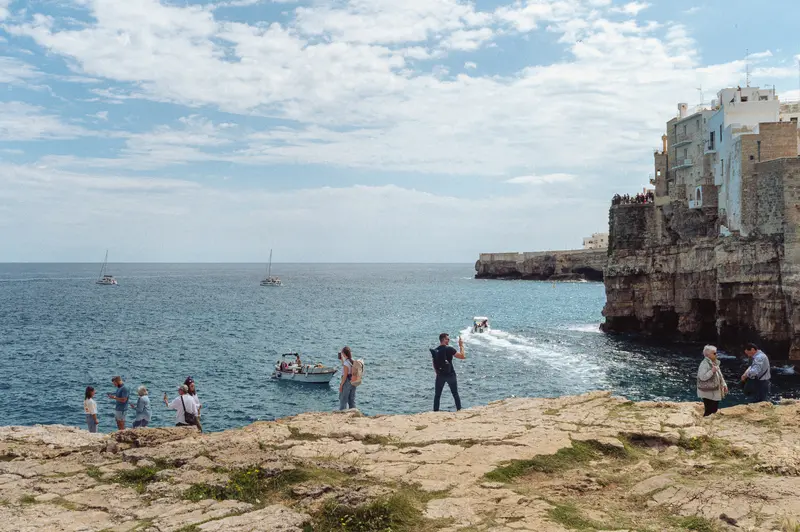 Coastal Beach Scene with Rocky Cliffs and Historic Waterfront Town