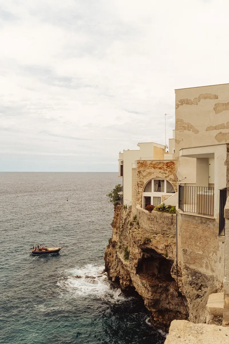 Clifftop House with Moored Boat in Mediterranean Coastal Town