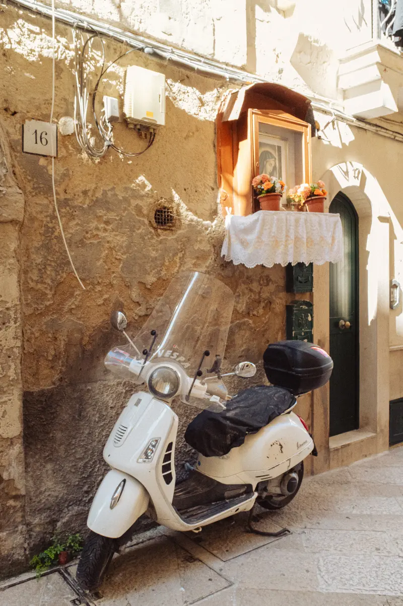 White Vespa Scooter Parked Outside Historic Italian Apartment Building