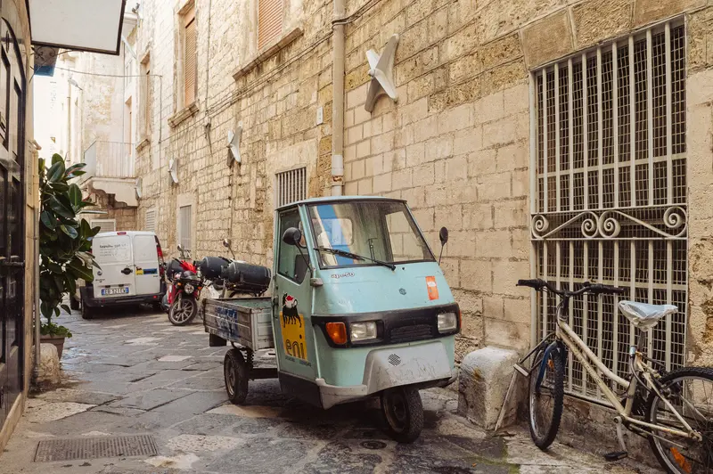 Three-Wheeled Delivery Vehicle Parked in Historic Mediterranean Alleyway