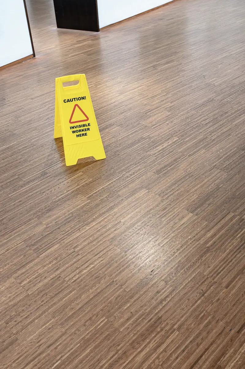 Yellow Caution Sign on Wet Wooden Floor