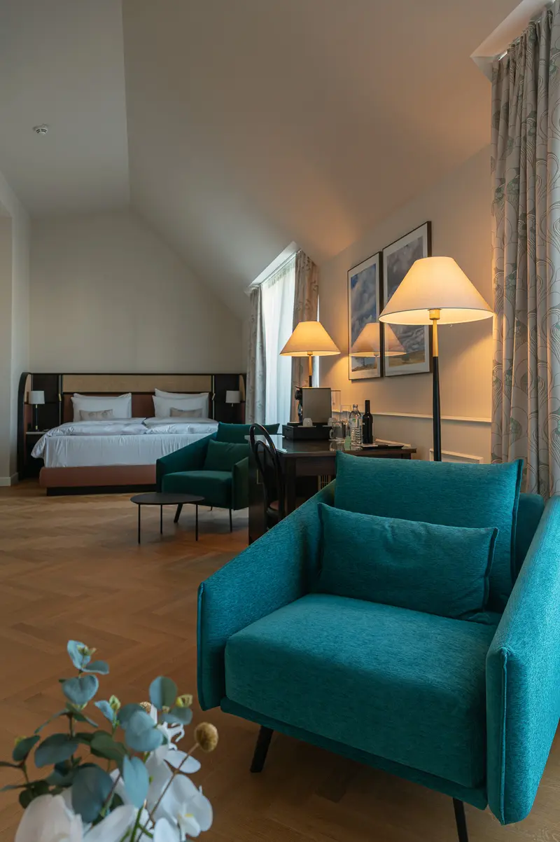 Hotel Chotek Vienna Suite with Teal Armchair and Bedroom Alcove