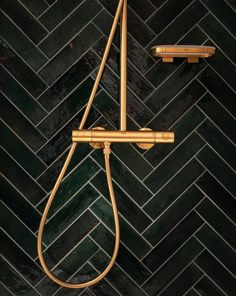 Gold Rainfall Shower System Against Black Herringbone Tile Wall