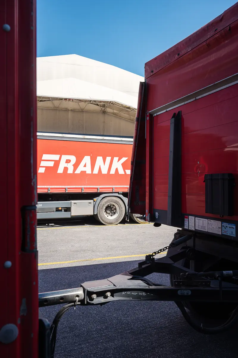 Frankstahl Red Truck Framed Between Loading Dock Trailers