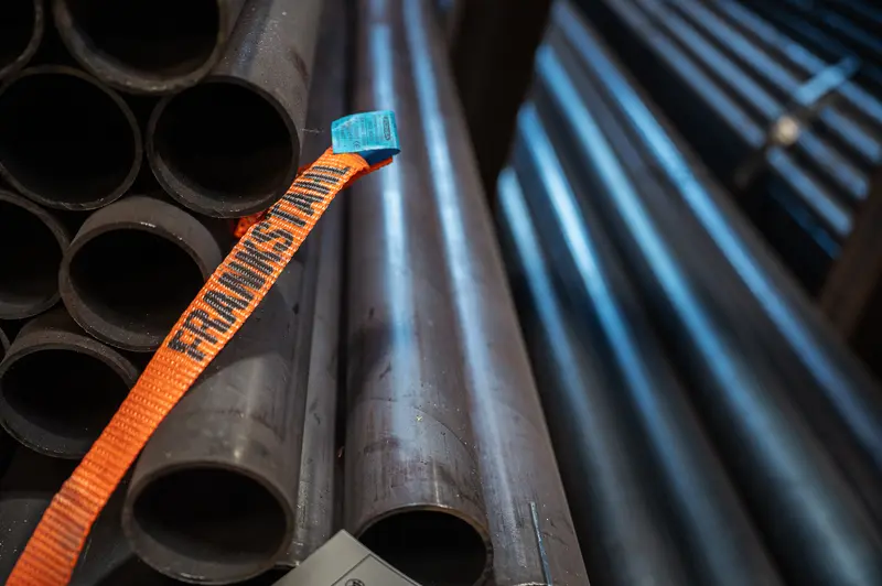 Frankstahl branded orange strap securing stacked steel pipes at Guntramsdorf