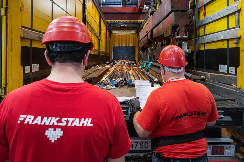 Two Frankstahl workers overseeing steel bar loading into delivery truck