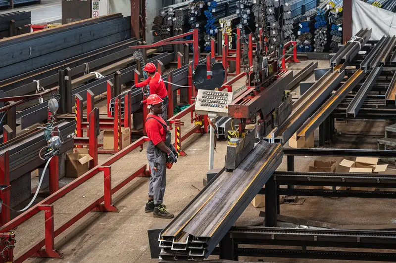 Two Frankstahl workers operating automated saw line in Guntramsdorf warehouse
