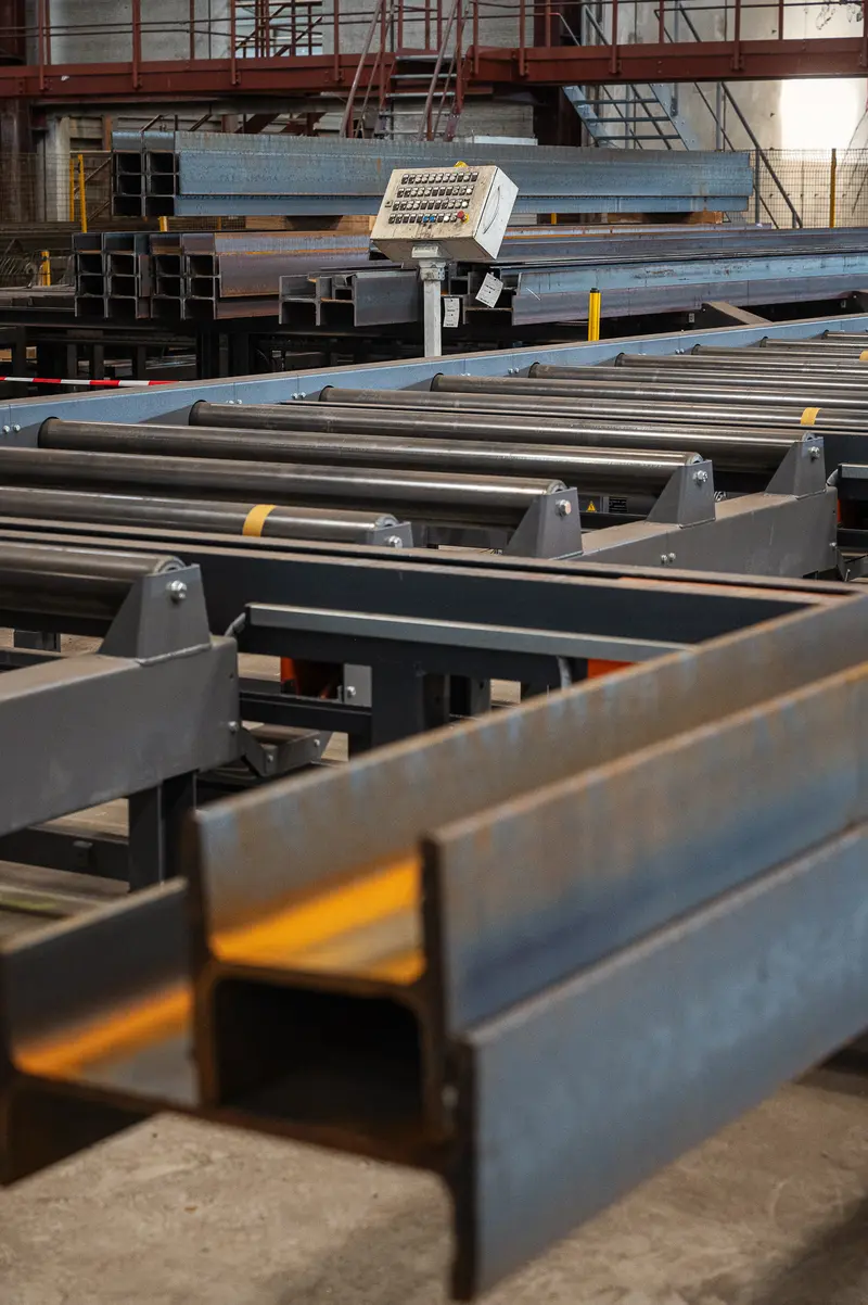 Steel H-beams on roller conveyor inside Frankstahl Guntramsdorf warehouse