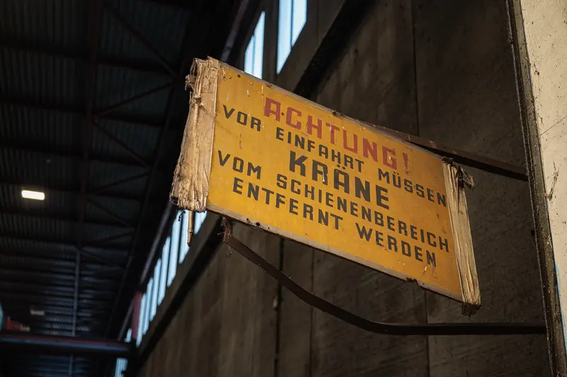 Aged German safety warning sign inside Frankstahl warehouse hall