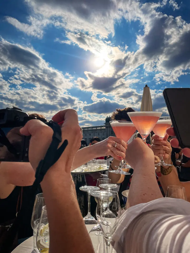 Outdoor Rooftop Toast with Pink Cocktails Under Dramatic Sky