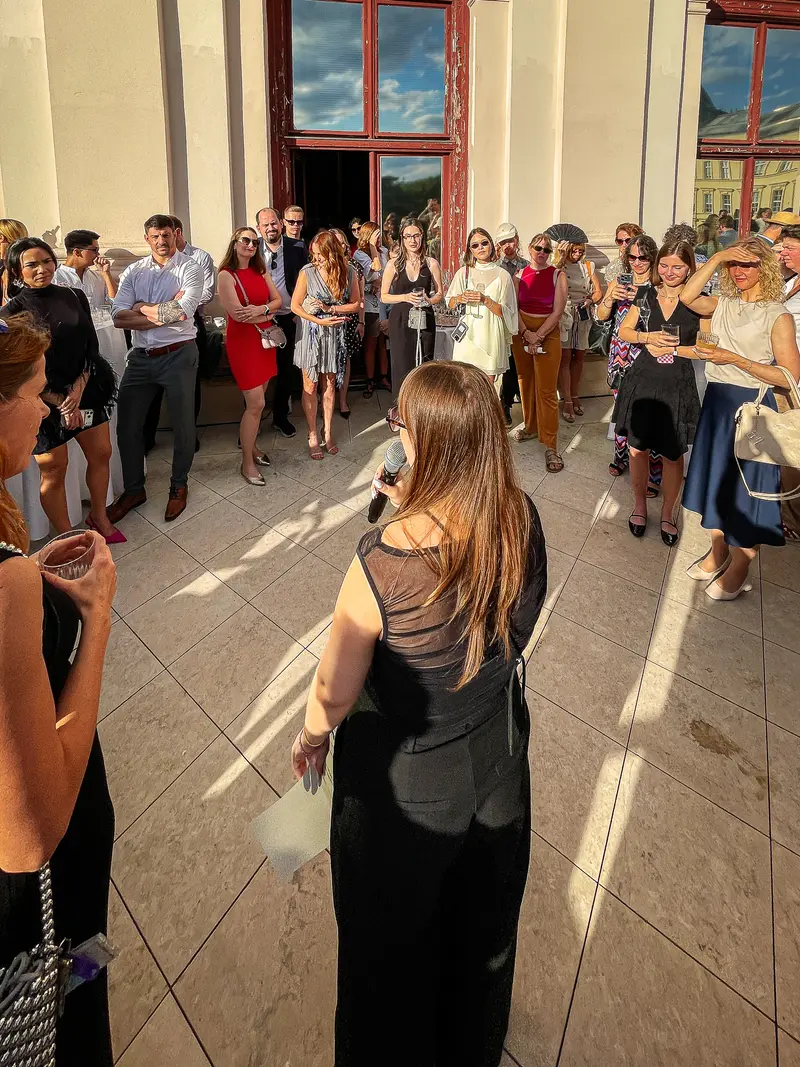 Speaker Addresses Crowd at Outdoor Evening Reception