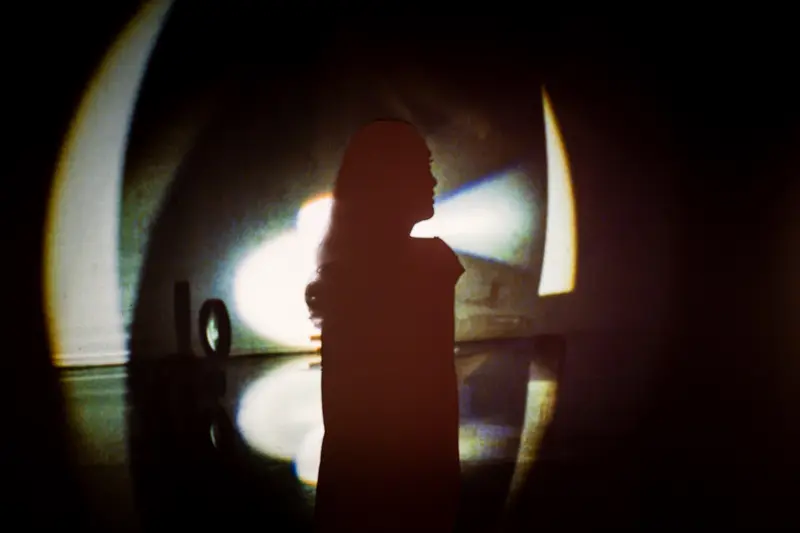 Dancer Silhouette Against Projected Light in Performance Space