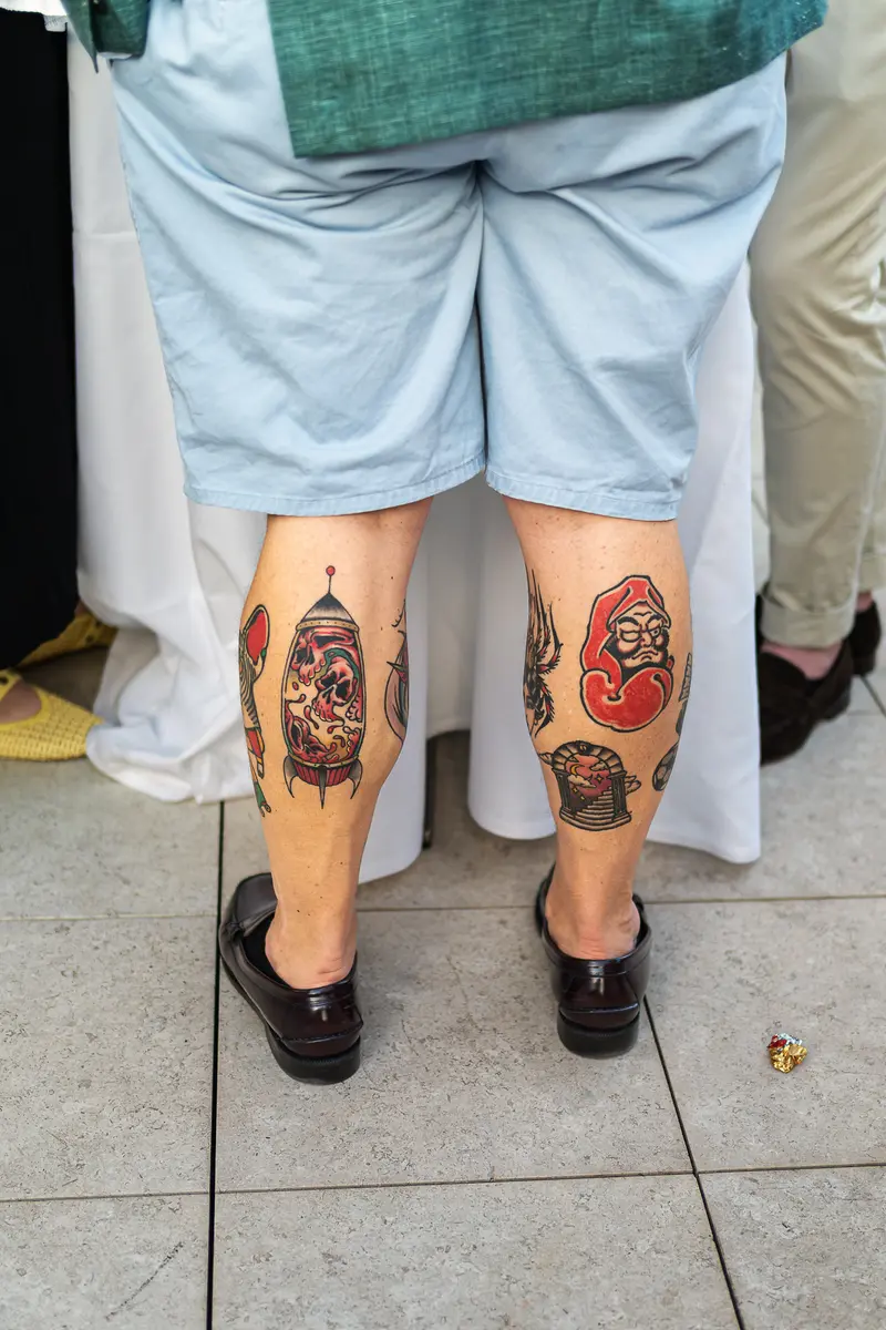 Detailed Tattoos on Both Calves of Event Attendee