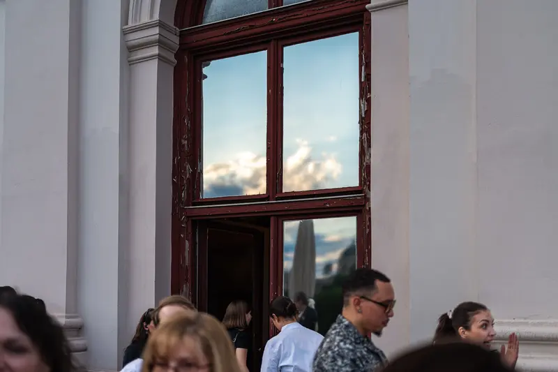 Guests Entering Historic Venue Doorway Under Evening Sky