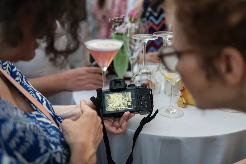Photographer Reviews Shot on Camera Screen at Cocktail Reception