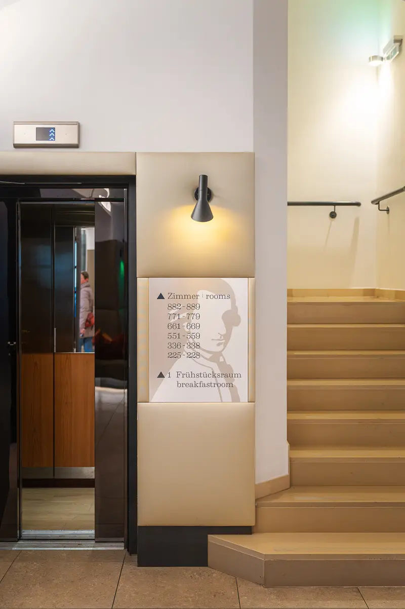 Mozart-Silhouette Room Directory Sign Beside Lift and Staircase at Hotel Das Tigra, Vienna