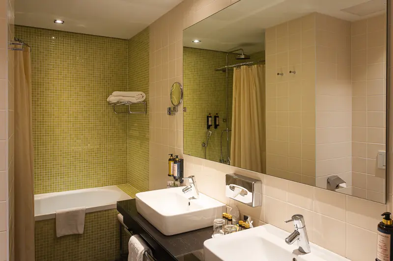 Twin-Basin Guest Bathroom with Olive Mosaic Tiling at Hotel Das Tigra, Vienna