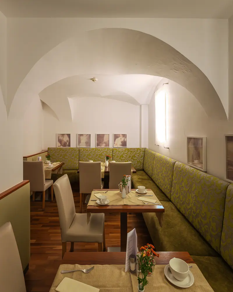 Vaulted breakfast room with green banquette seating at Hotel Das Tigra, Vienna