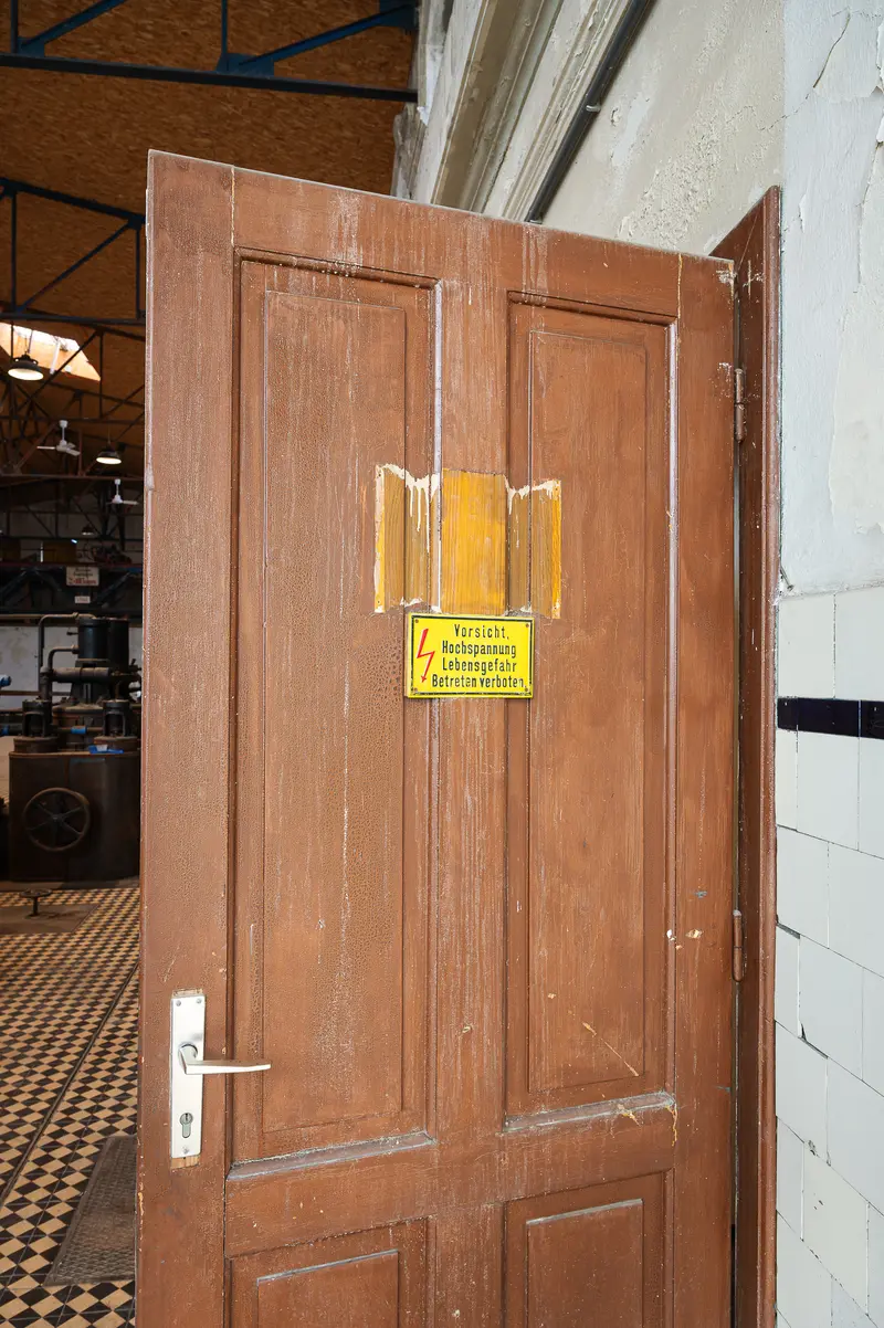 Historic high-voltage warning sign on wooden door, Glanzstoff St. Pölten Open House 2026