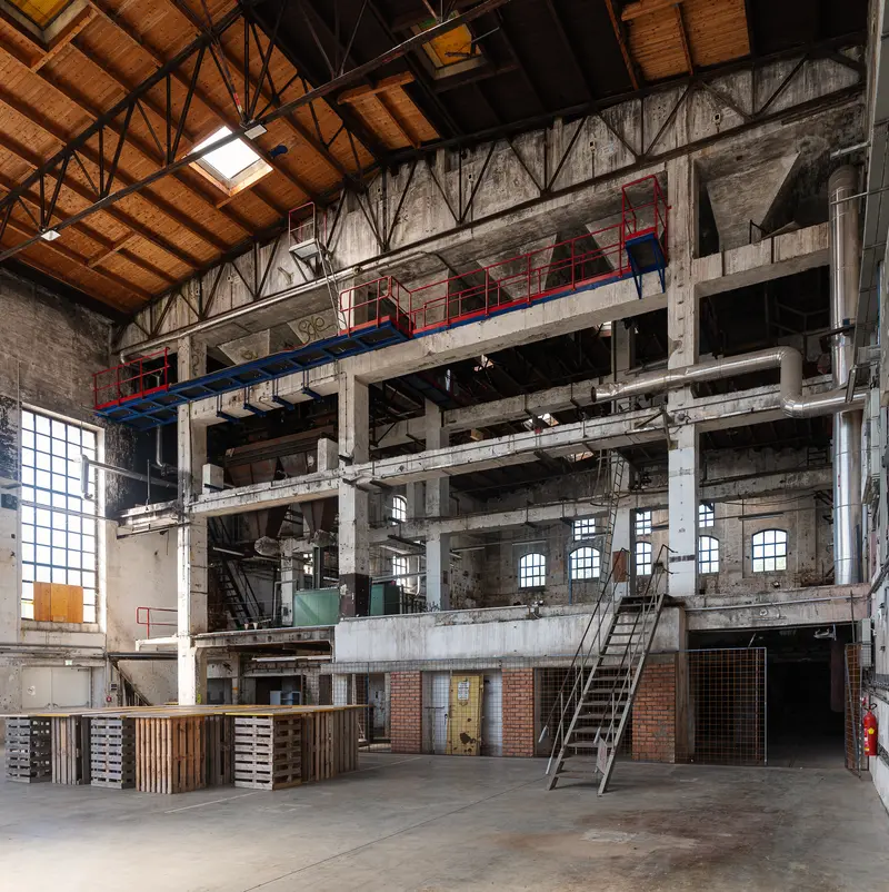 Multi-storey concrete production hall with red and blue gantry, Glanzstoff St. Pölten